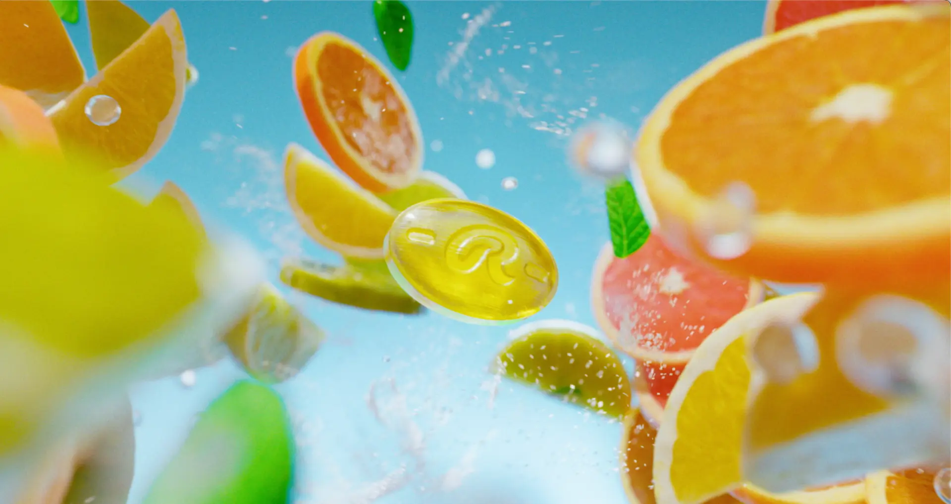 Ricola lozenge floating among citrus fruit and water