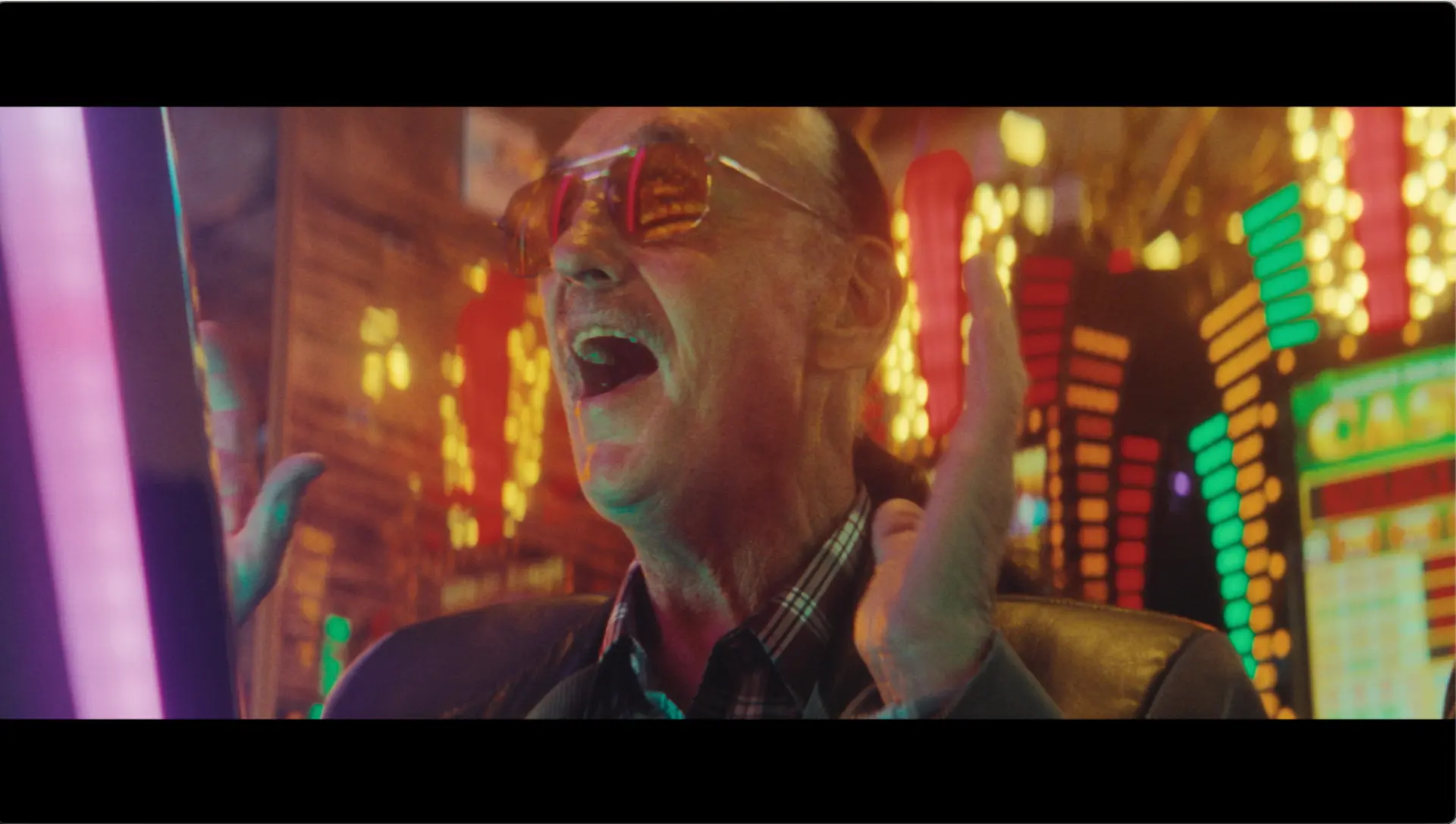 A man celebrating at a brightly lit casino machine