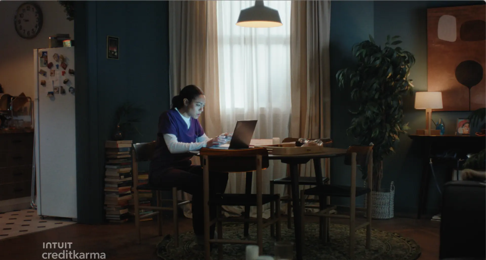 A woman working on a laptop at her dining table